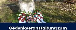 Beitragsbild Ankünding Volkstrauertag 2025 © Pressestelle Der Gedenkstein für die Opfer von Krieg und Gewaltherrschaft auf dem Stadtfriedhof St. Maximi mit davor abgelegten Blumenkränzen; Titel des Artikels